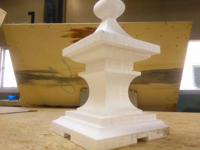 A white EPS foam pagoda-lantern form cut on the FoamCube, used as a master pattern for a concrete mould, on a workbench