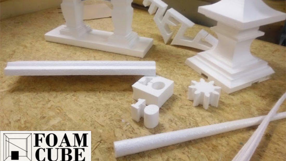 A spread of white foam parts cut on the FoamCube — balustrade, Greek-key fret, finial, gear and cylinders — with the FoamCube logo