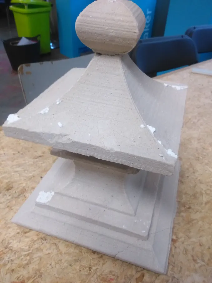 Ein grauer Gips-Finial, gegossen in einer heißdrahtgeschnittenen Schaumform, in einem Makerspace